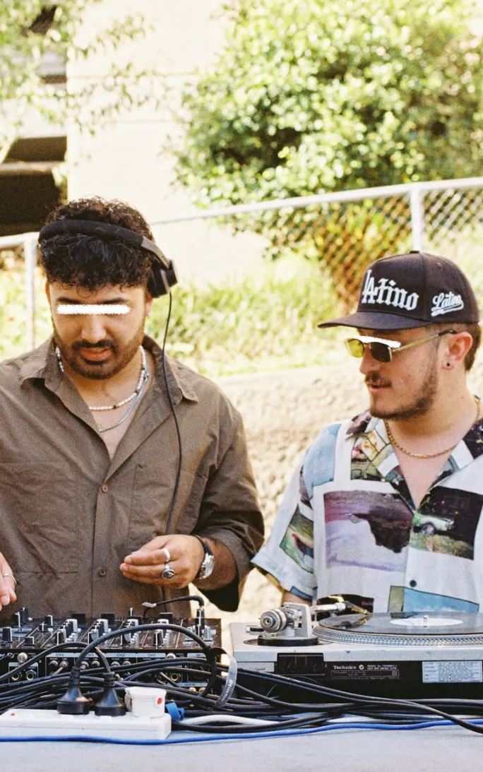 Two DJs playing vinyl outdoors
